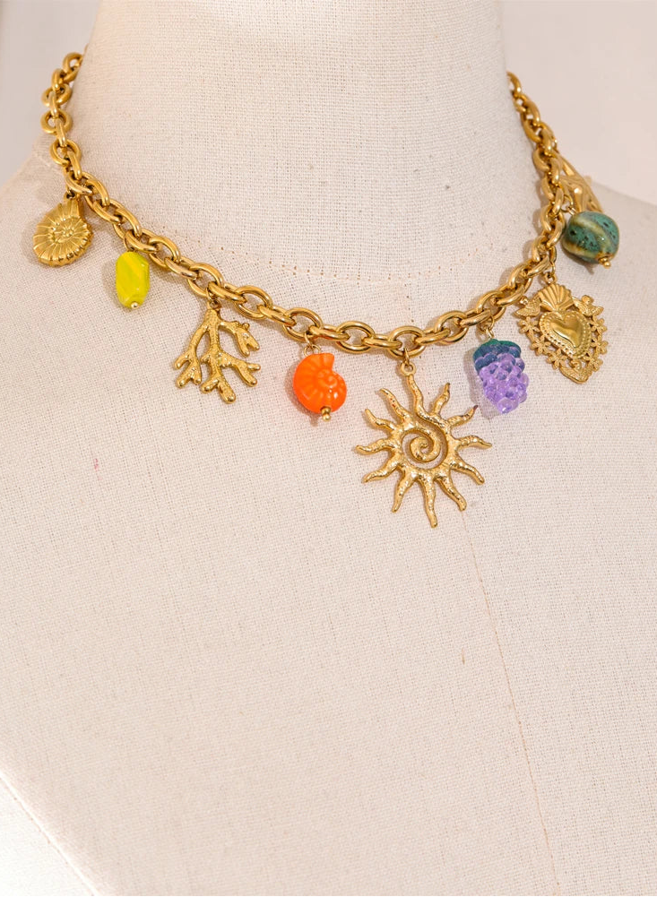 Gold necklace with colorful charms on a mannequin bust.