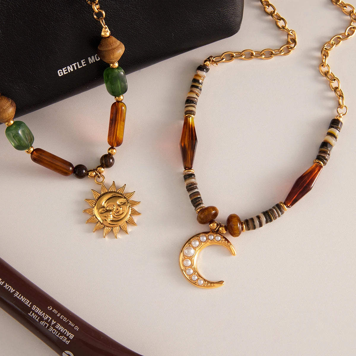 Necklace with sun and moon pendants on a white surface