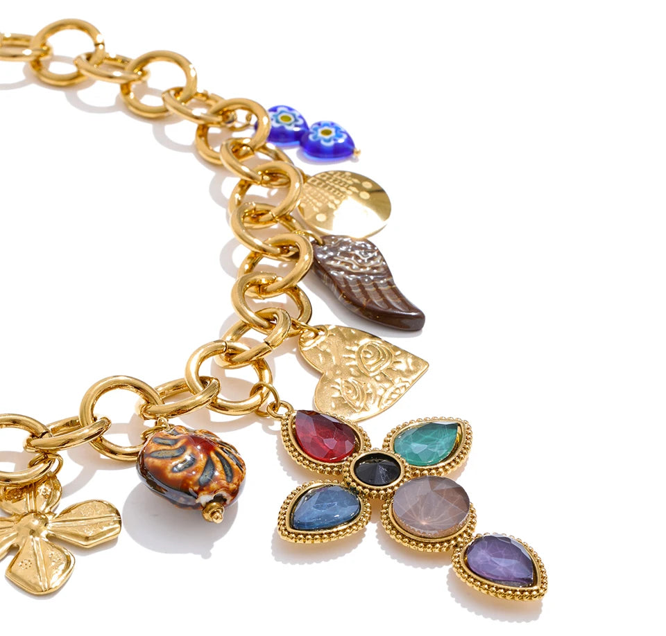 Gold charm cross necklace with multicolor gemstones and chunky chain statement jewelry for women closed up 