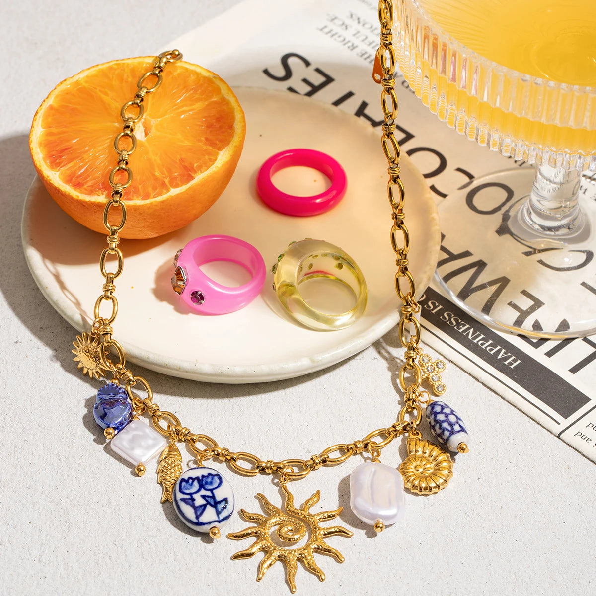 Gold necklace with charms on a newspaper background