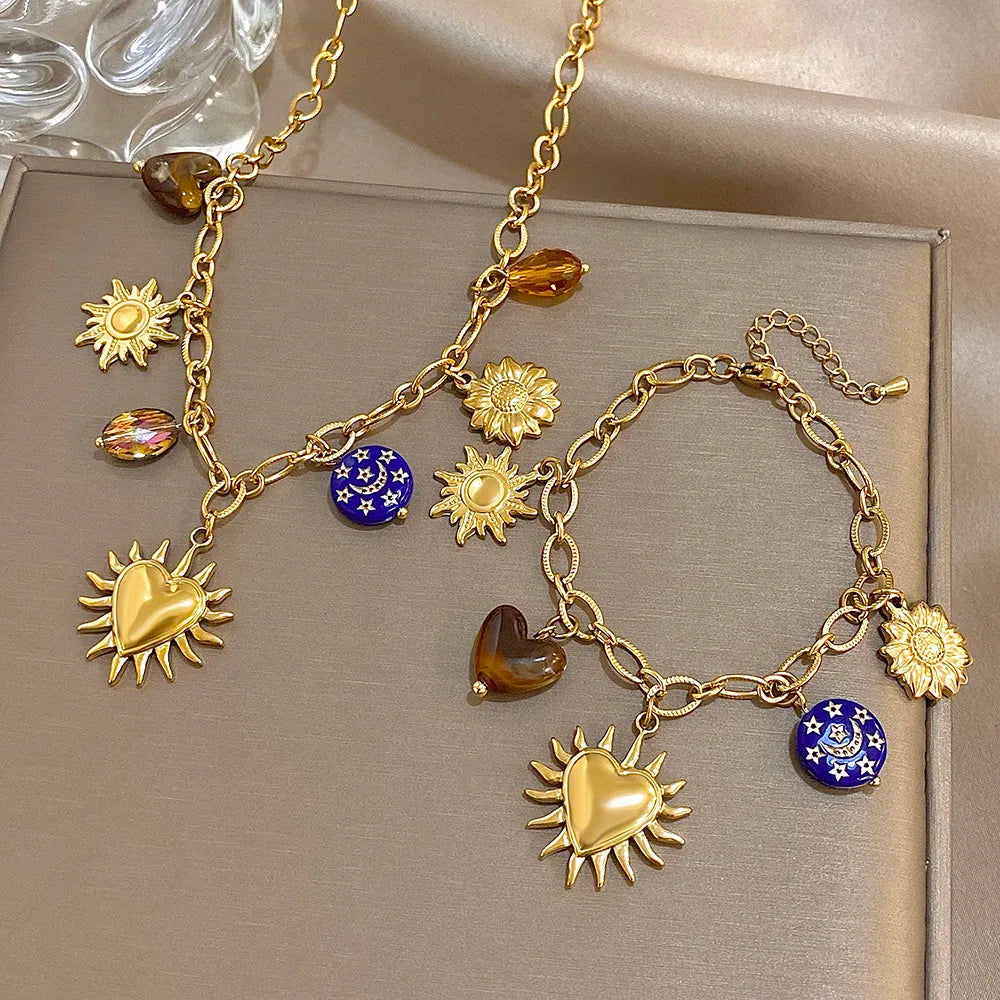 Gold necklace with various charms on a neutral background