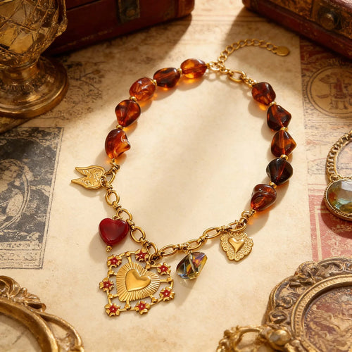 Gold bracelet with amber beads and heart charms on an old book