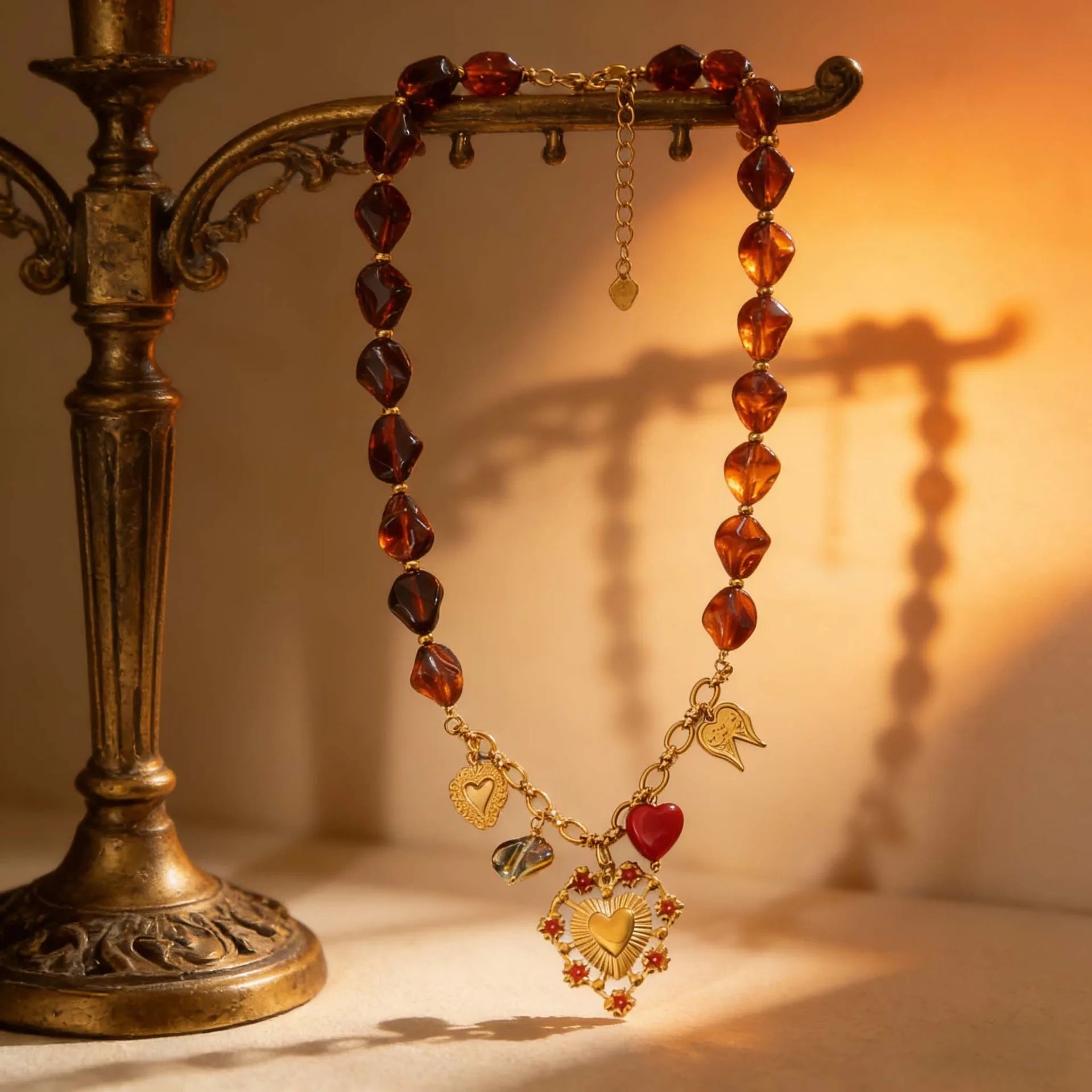Necklace with heart-shaped charms on a decorative stand against a warm background